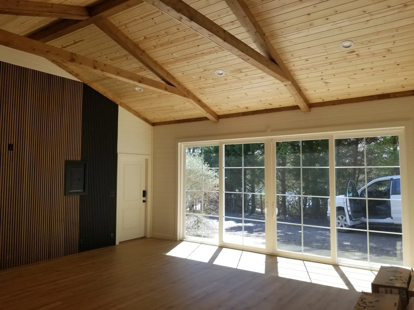 Sunlit custom home addition with exposed wood beams and sliding glass doors in Middle Georgia